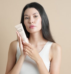 Woman holding a tube of facial cleanser