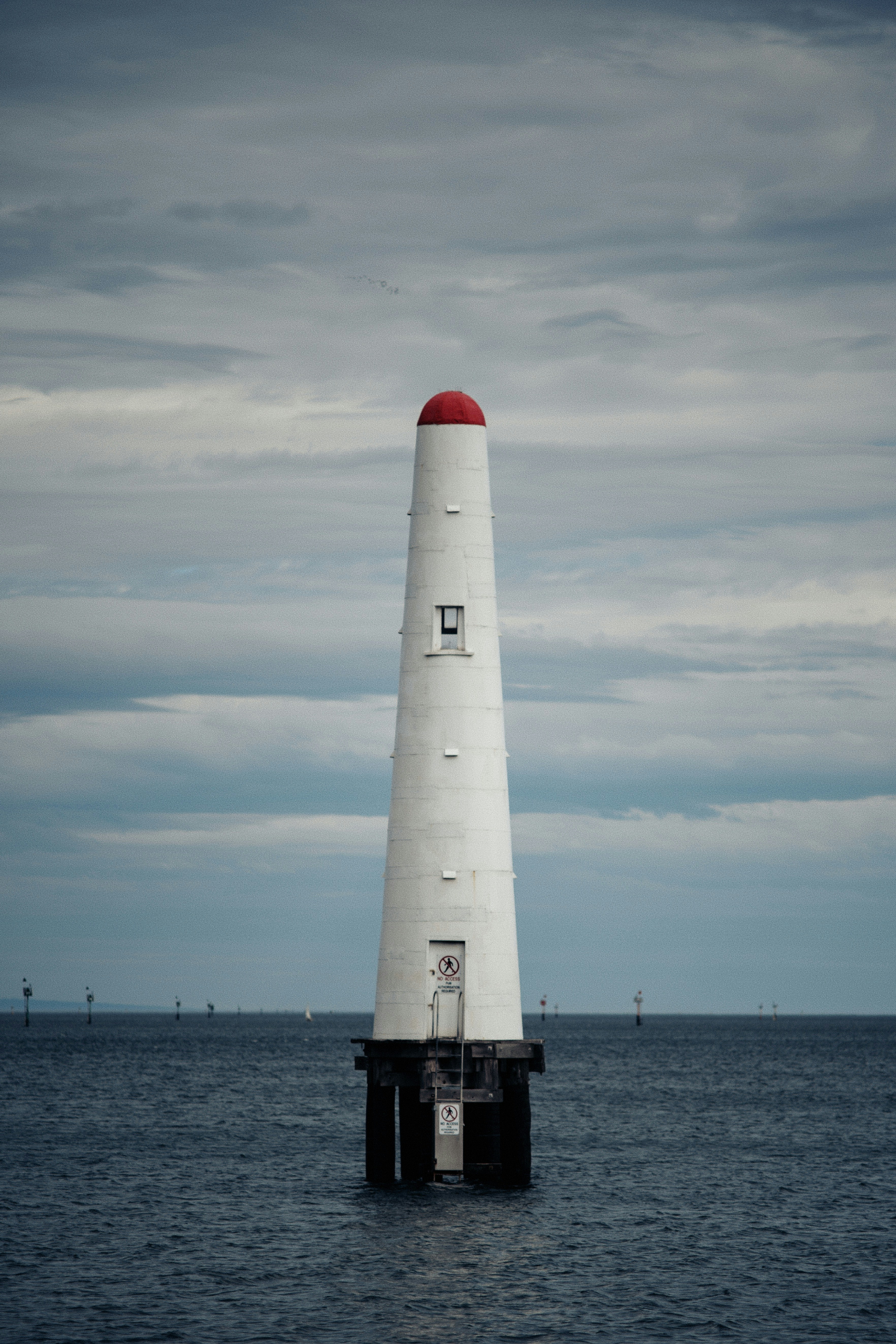 Un phare blanc se dresse fièrement dans l’océan.
