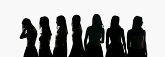 Silhouettes of seven women against a white background.