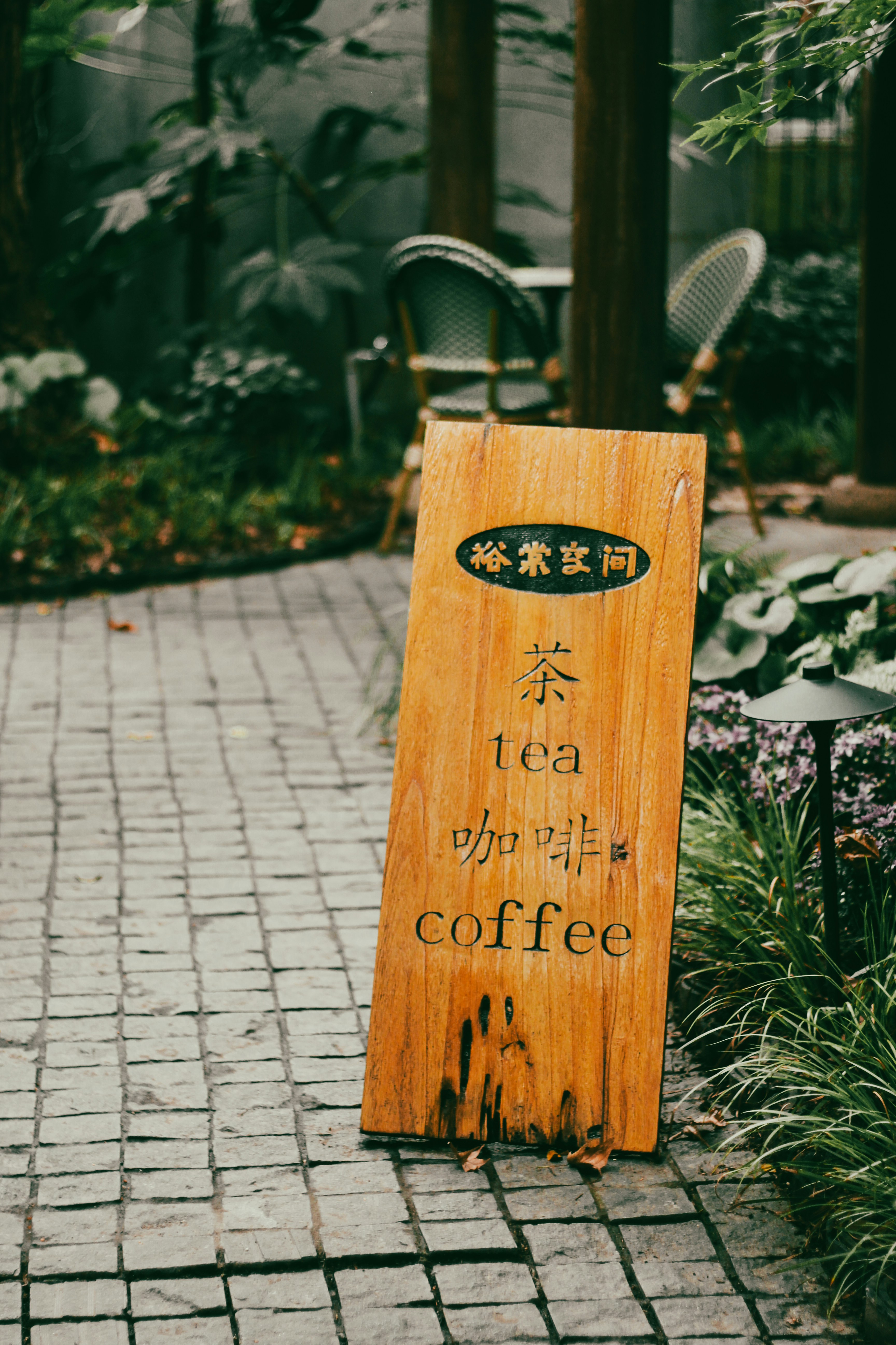 Wooden sign advertising tea and coffee outdoors.