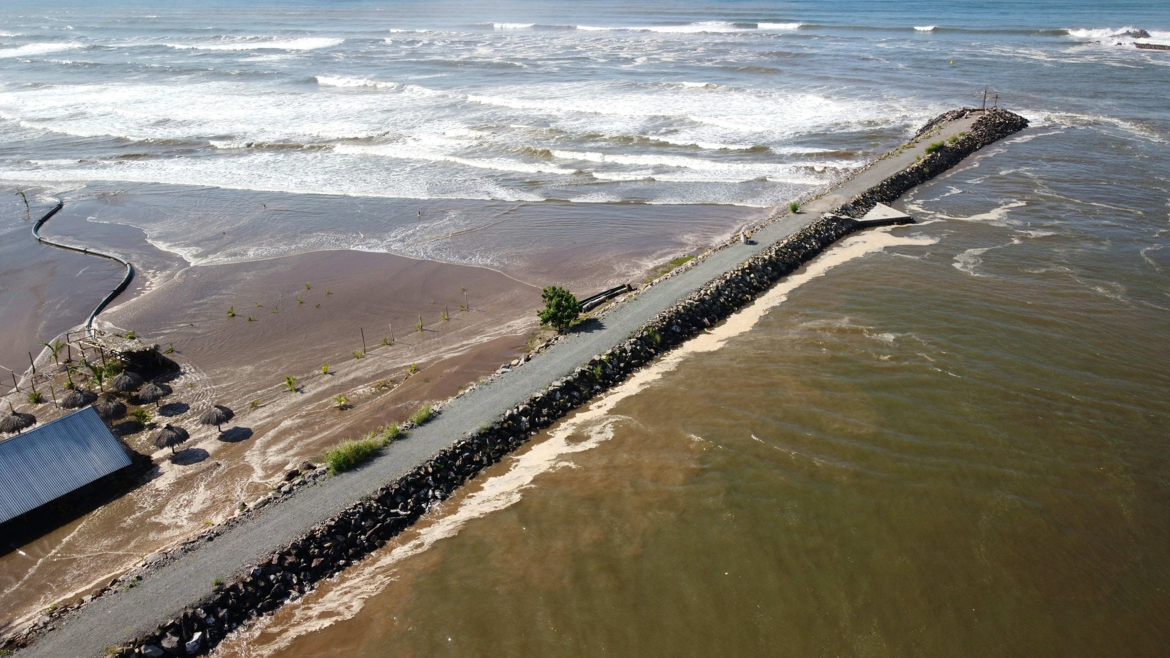 Long pier extending into the choppy ocean water