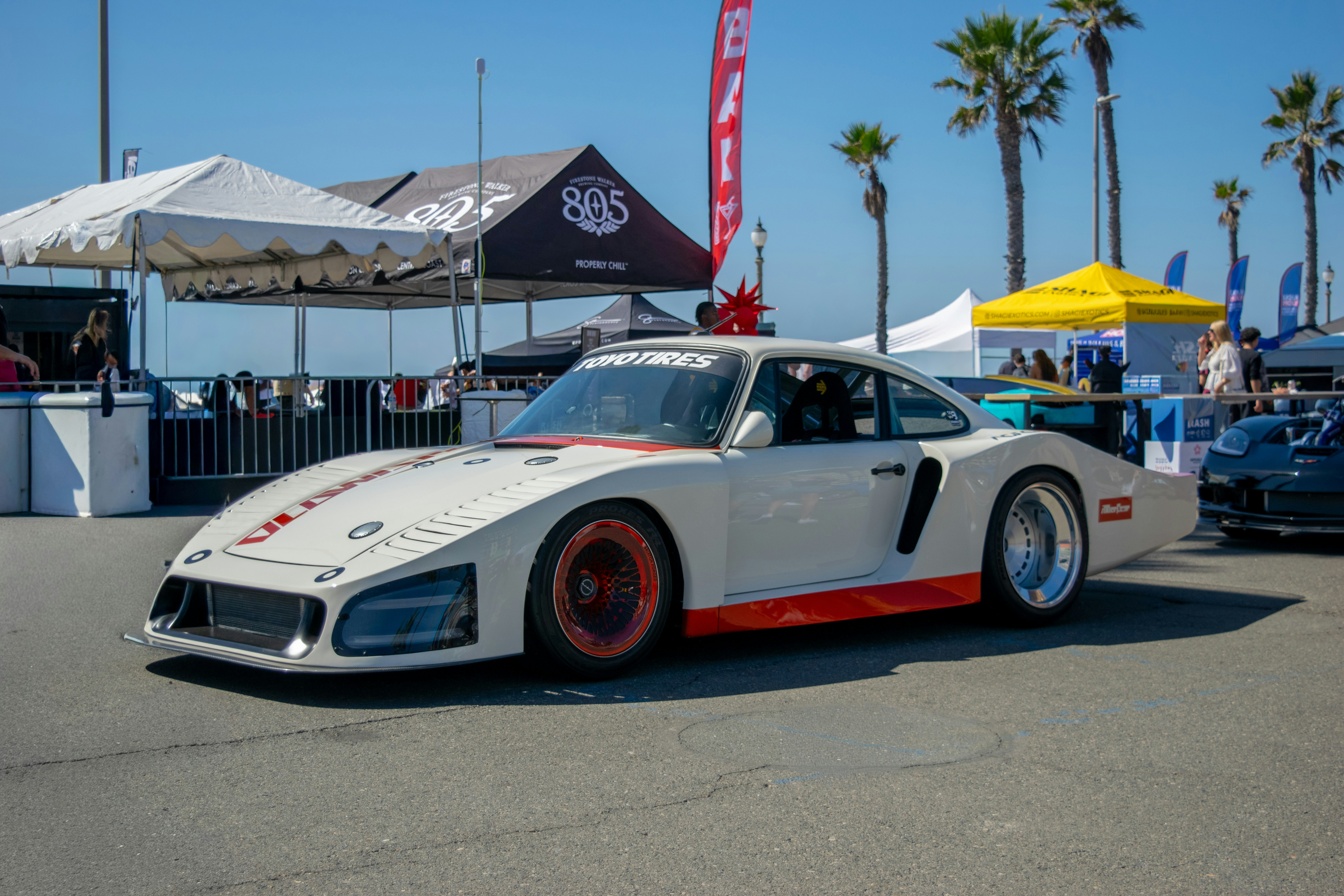 White race car with orange accents at event