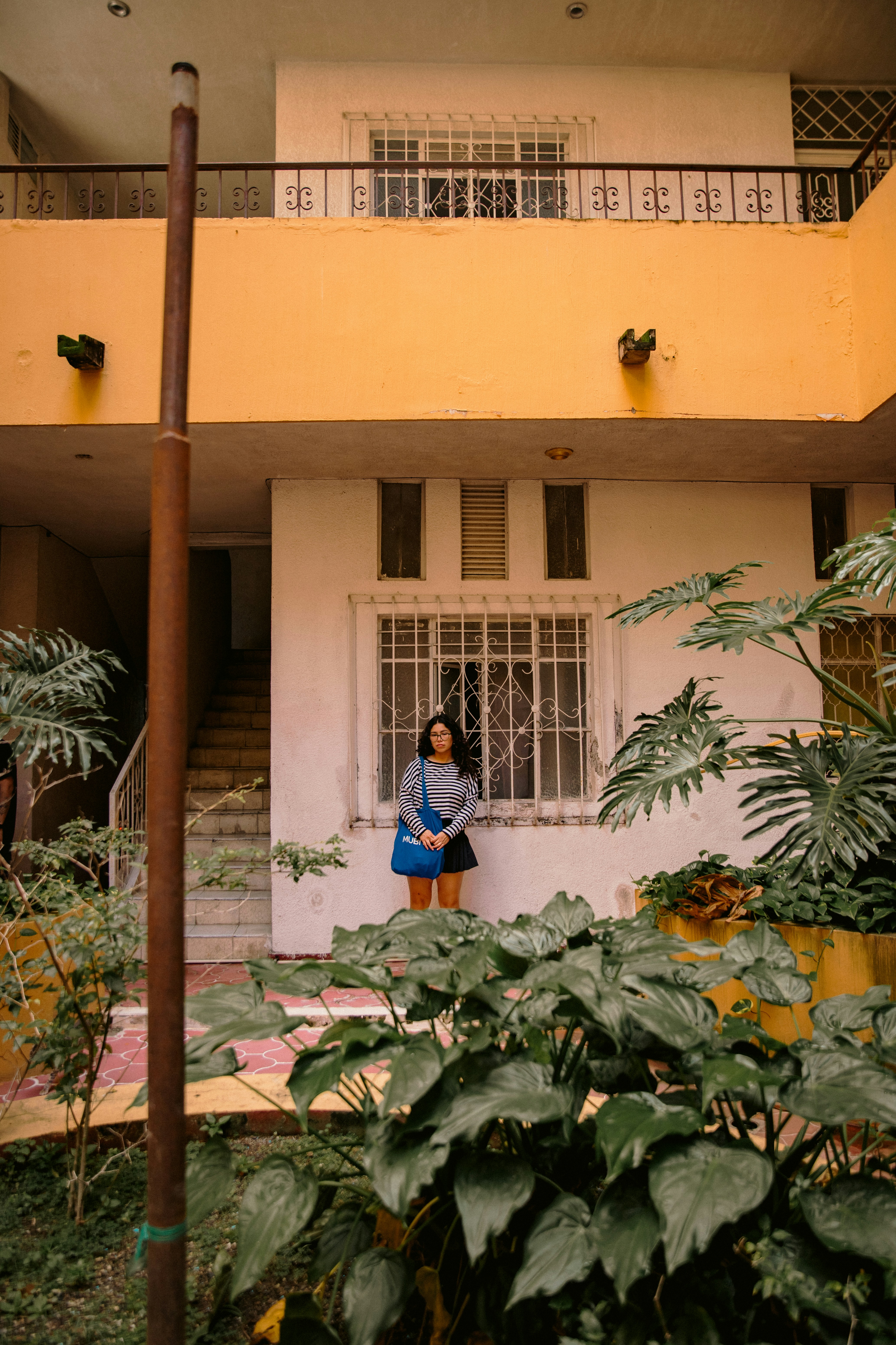 Woman standing in front of a building with plants