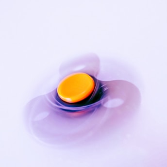 A spinning fidget toy with an orange center.