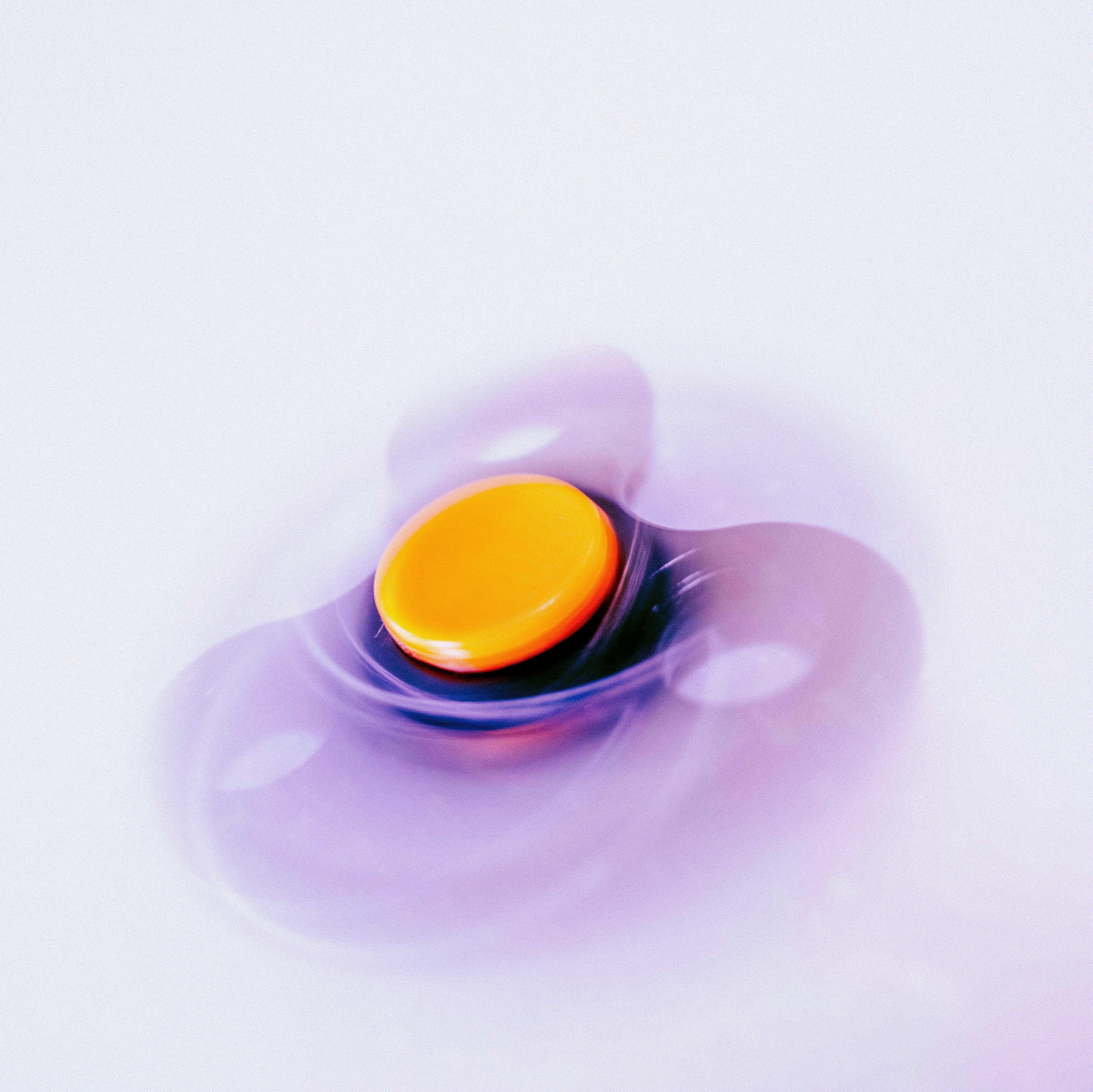 Spinning fidget toy creating hypnotic ripples in purple liquid . Therapeutic sensory device captured in motion with stunning minimalist aesthetics. Perfect for mental health content, stress relief campaigns, ADHD awareness, mindfulness blogs, and wellness brand storytelling. Calming pastel tones meet dynamic movement.