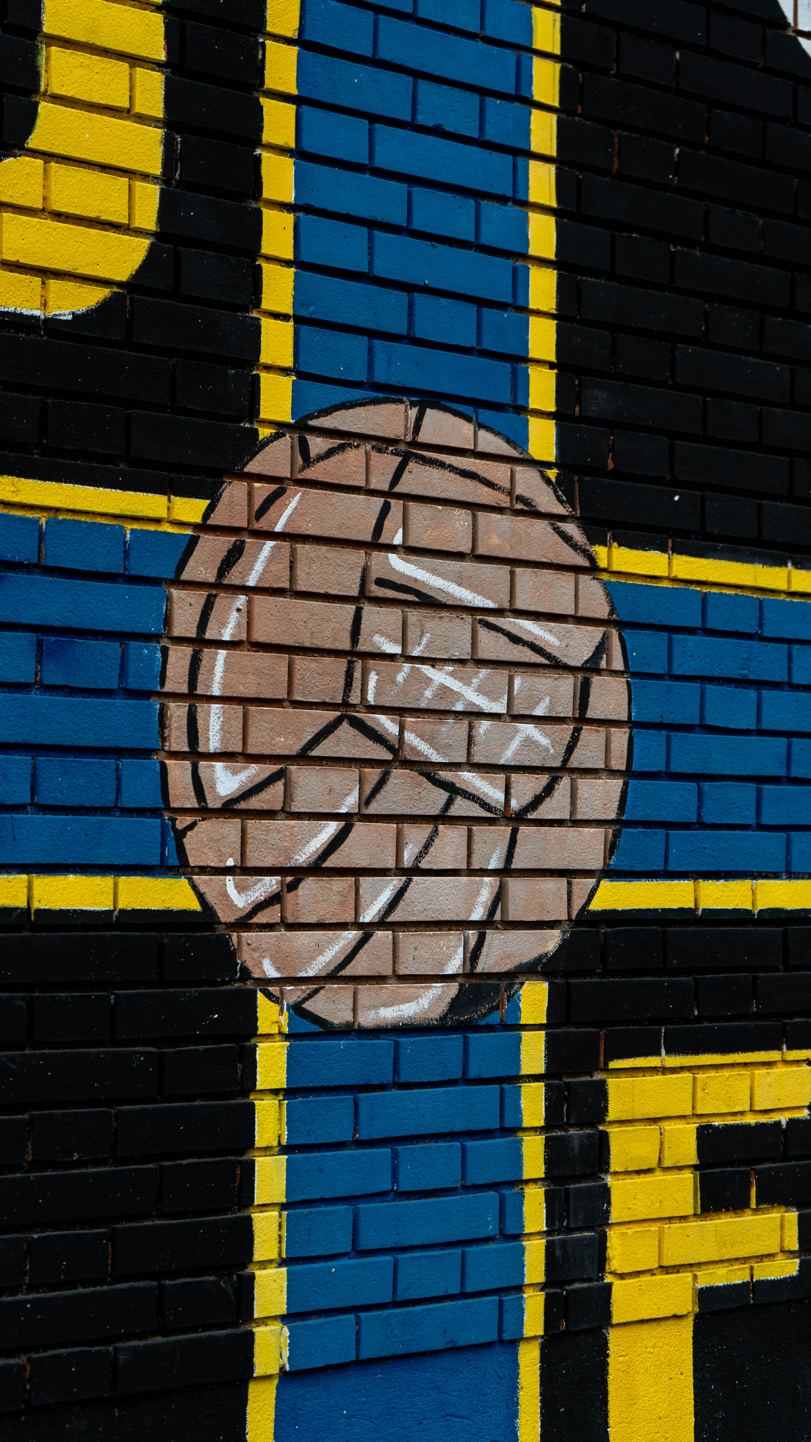 Mural of a vintage soccer ball on brick wall.