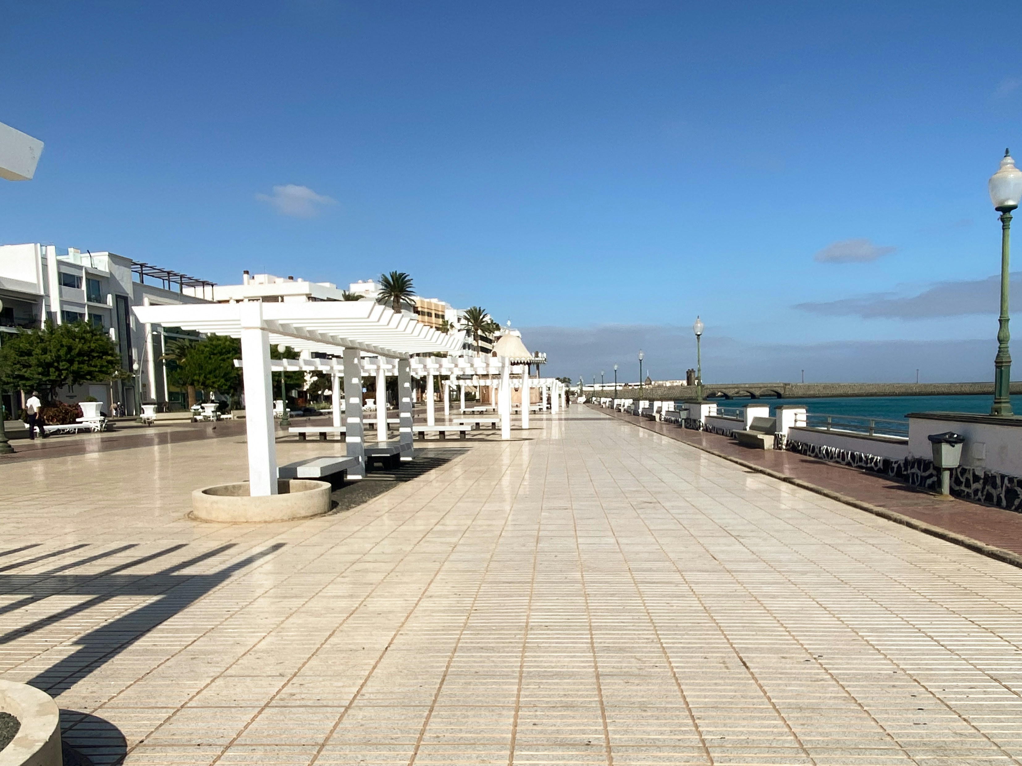 Empty promenade with white pergolas and ocean view