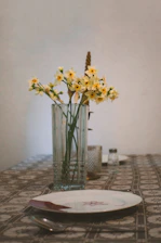 Daffodils in a vase on a table setting.