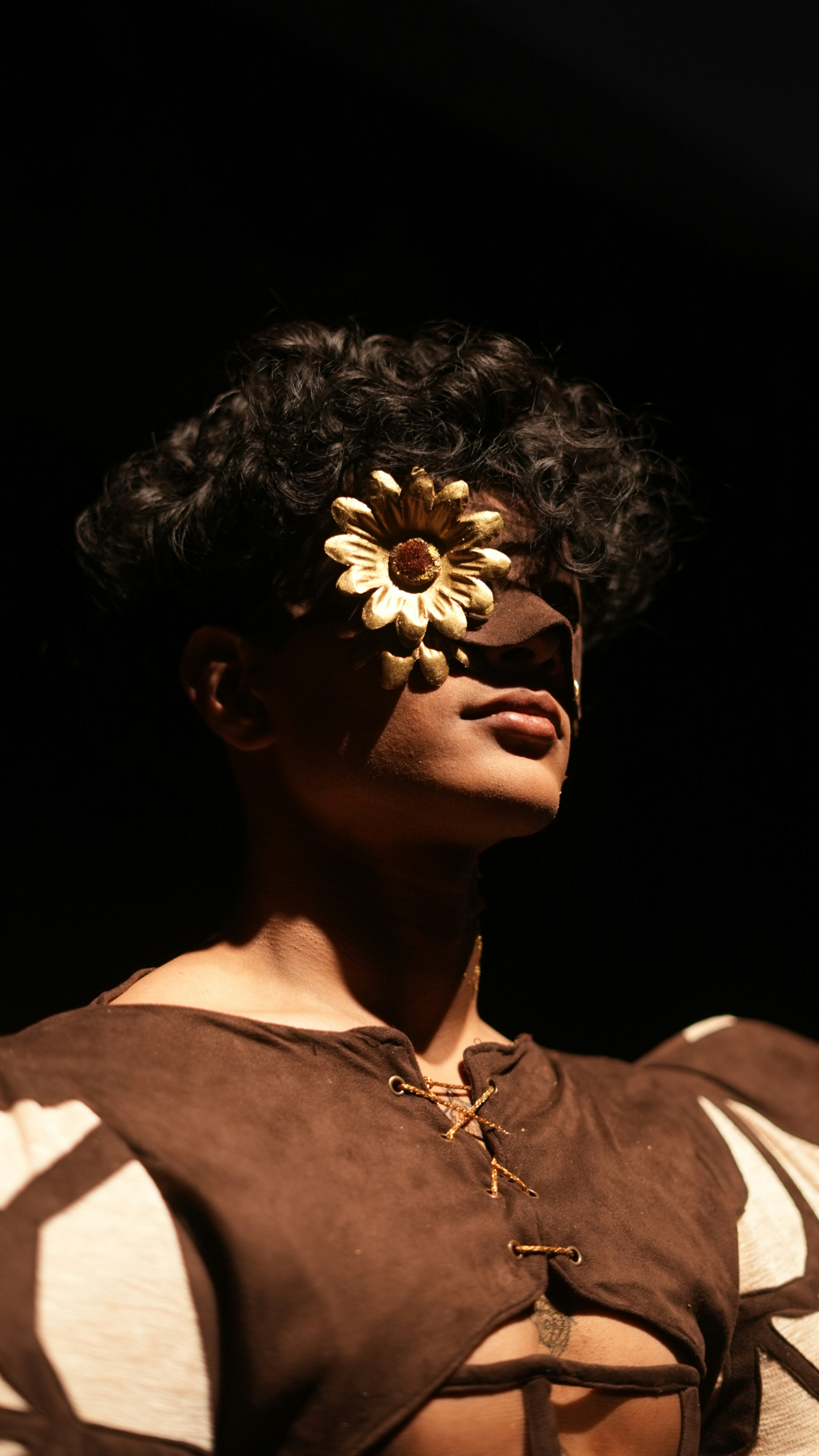 Person with a golden flower covering one eye