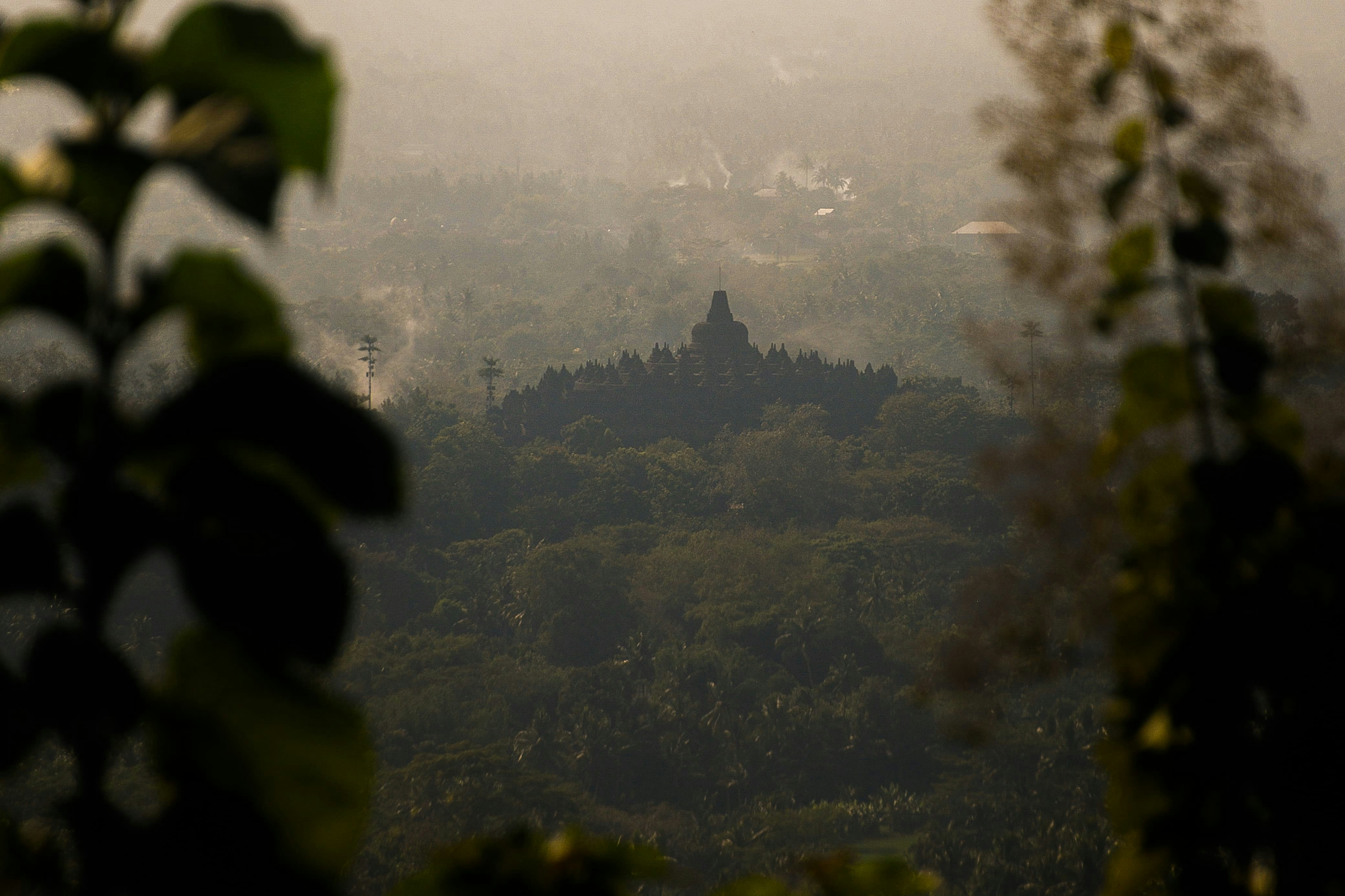 Ancient temple structure atop a lush green hill.