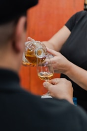 Pouring amber liquid from bottle into glass