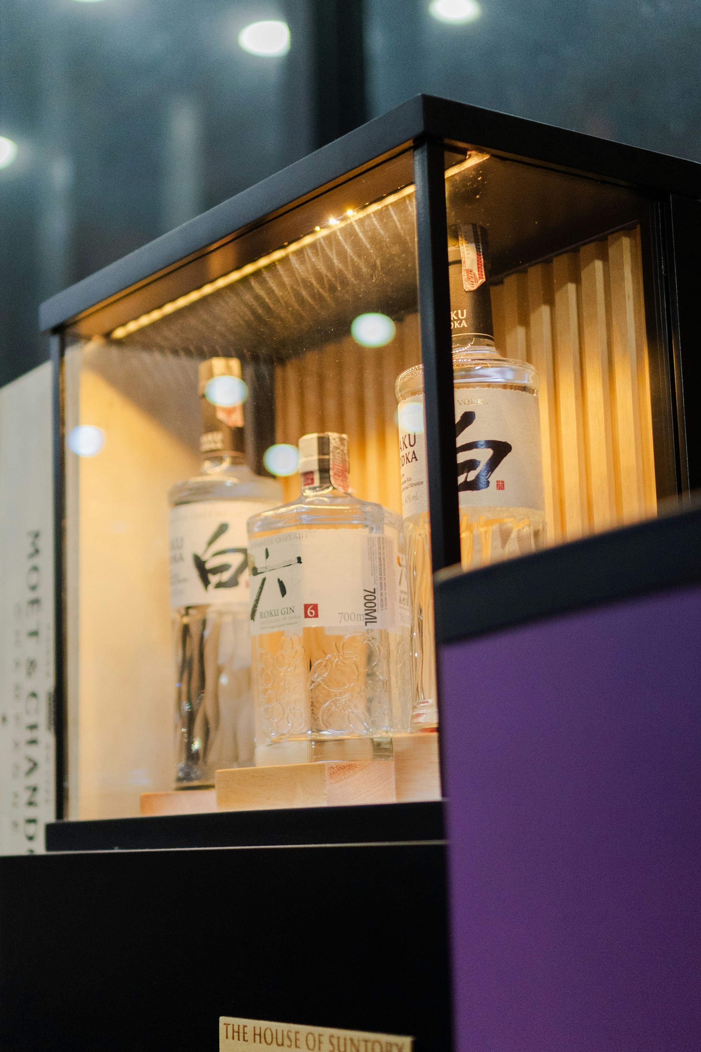 Bottles of white spirit displayed in a lighted cabinet