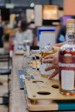 Pouring whiskey into tasting glasses at a bar.
