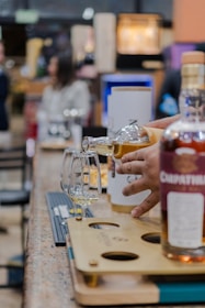 Pouring whiskey into tasting glasses at a bar.