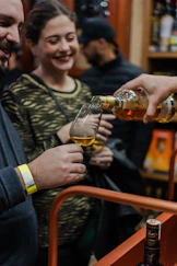 Pouring amber liquid into a tasting glass
