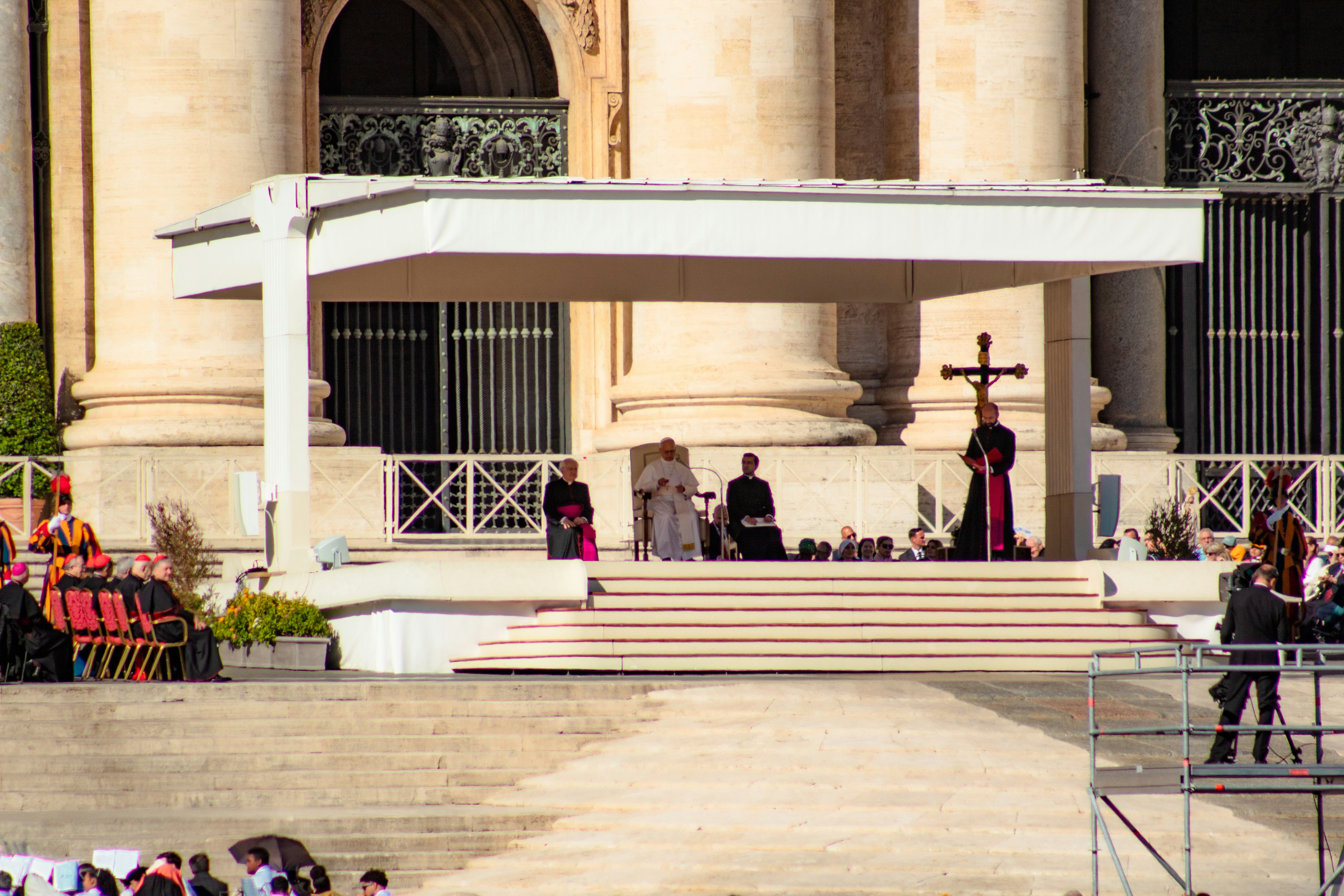 Religious ceremony on elevated stage with cross