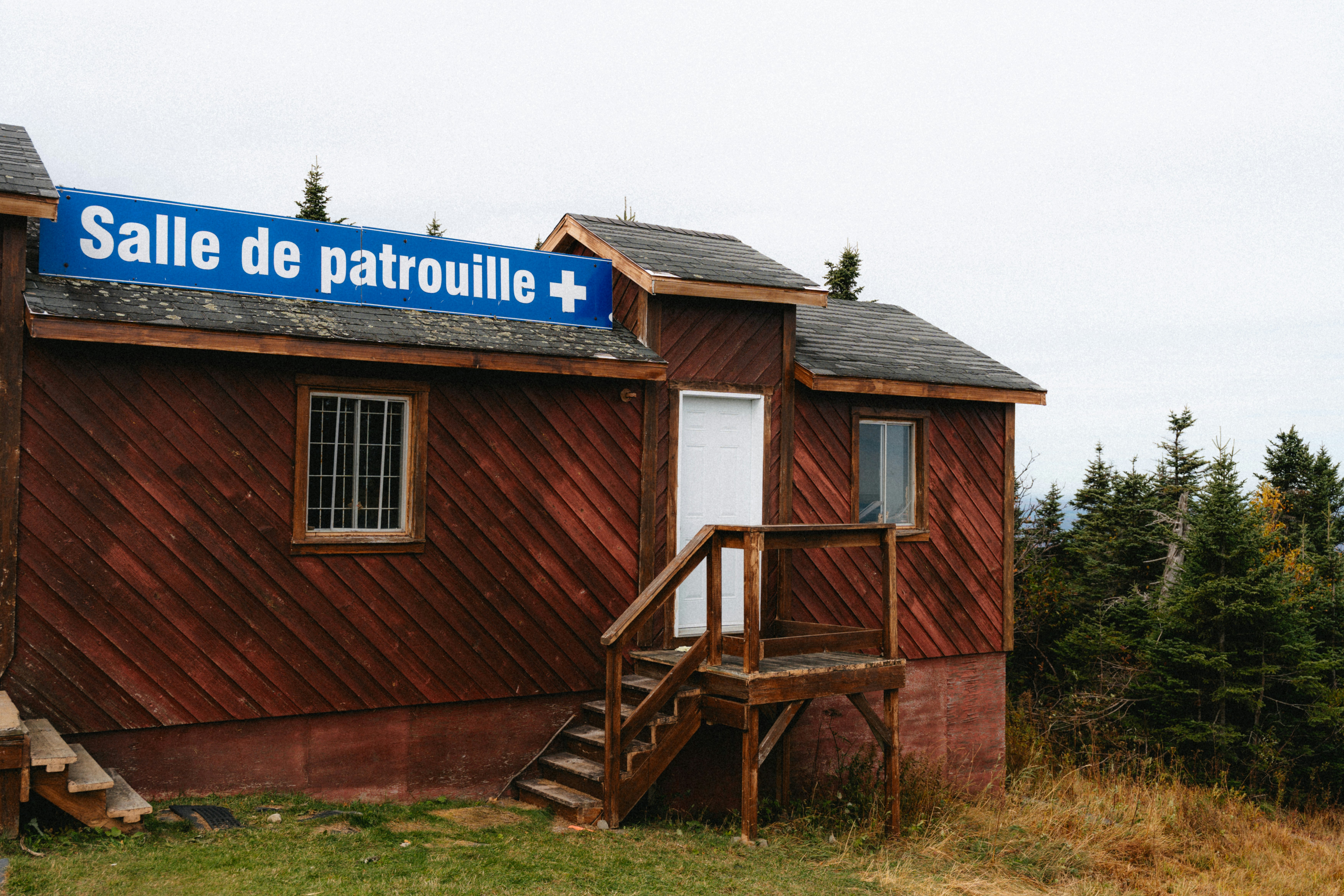Wooden building with 'salle de patrouille' sign.