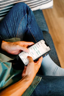 Person using a smartphone on a couch.