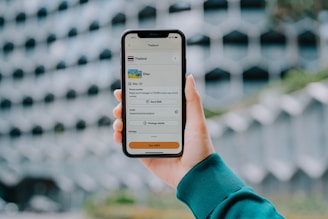 Hand holding a smartphone displaying a payment app.