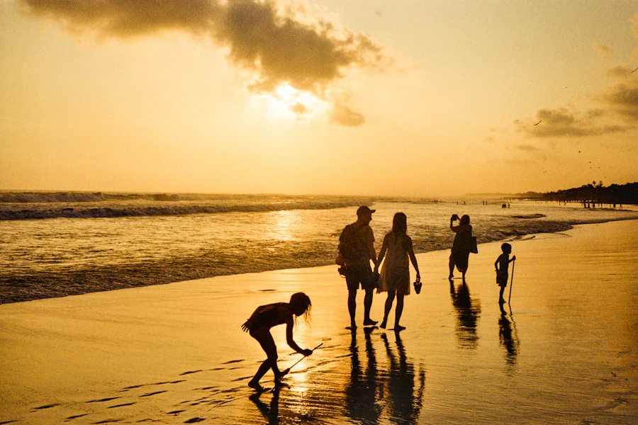 Familia caminando por la playa al atardecer