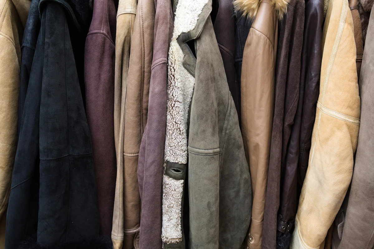 Barisan jaket kulit dan suede aneka warna tergantung rapat memenuhi rak toko