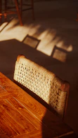Woven chair and wooden table in warm sunlight