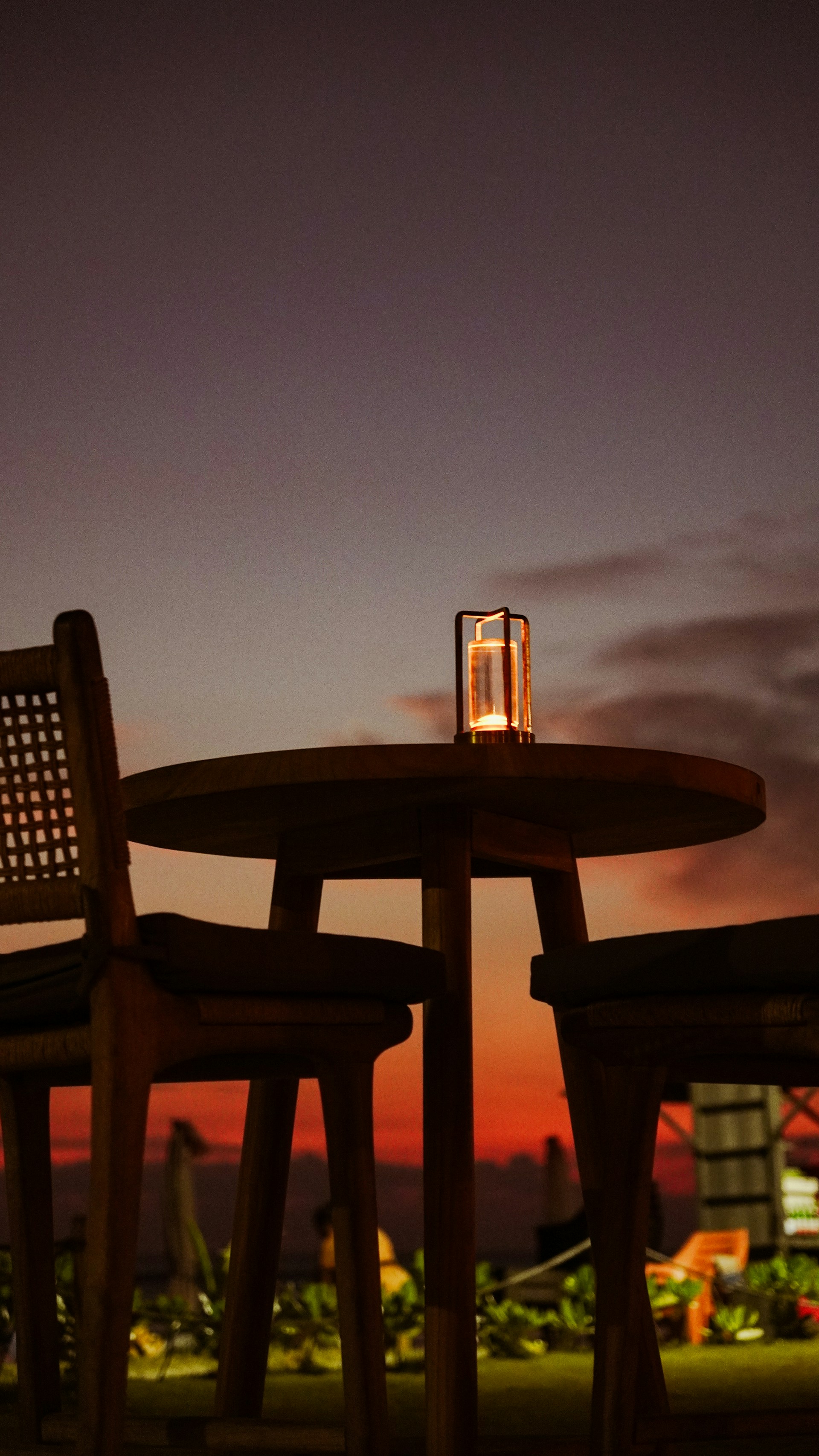 Table and chairs with candle at sunset