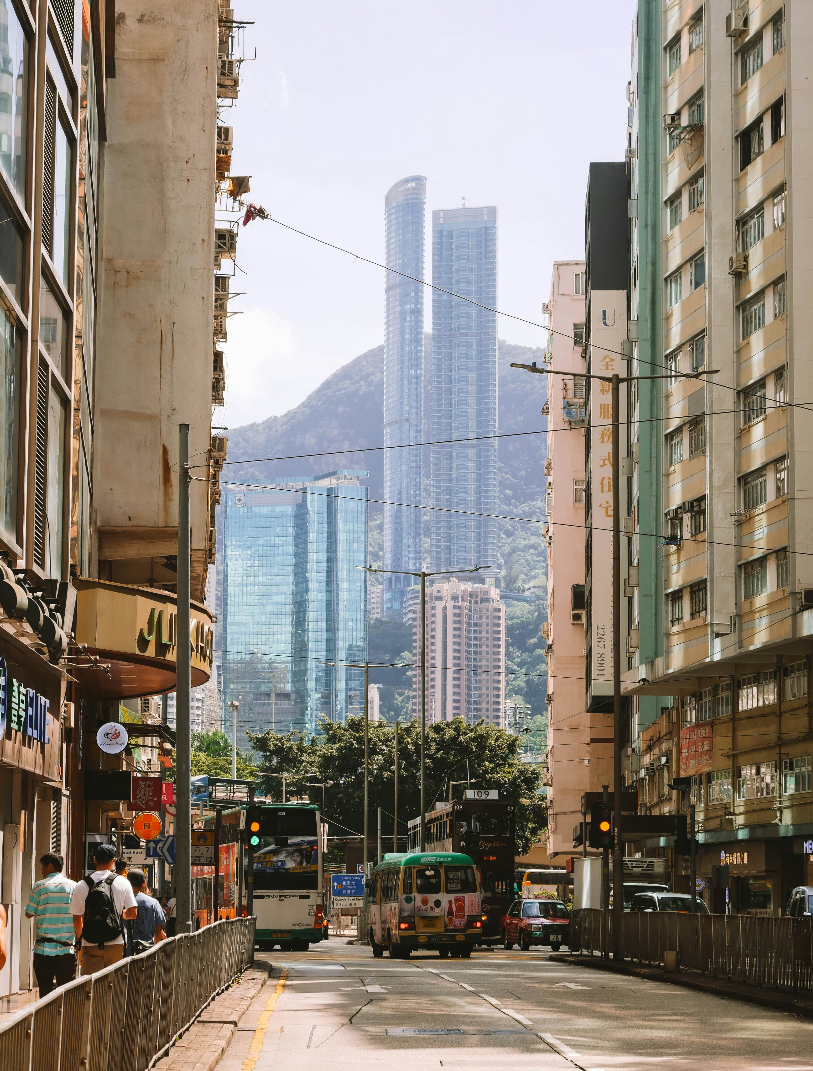 Strada cittadina con grattacieli moderni e montagne oltre.