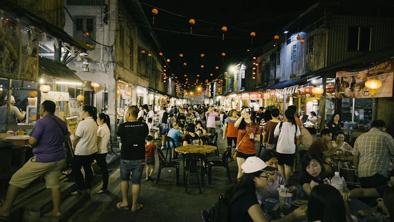A busy night market street lined with food stalls and lanterns