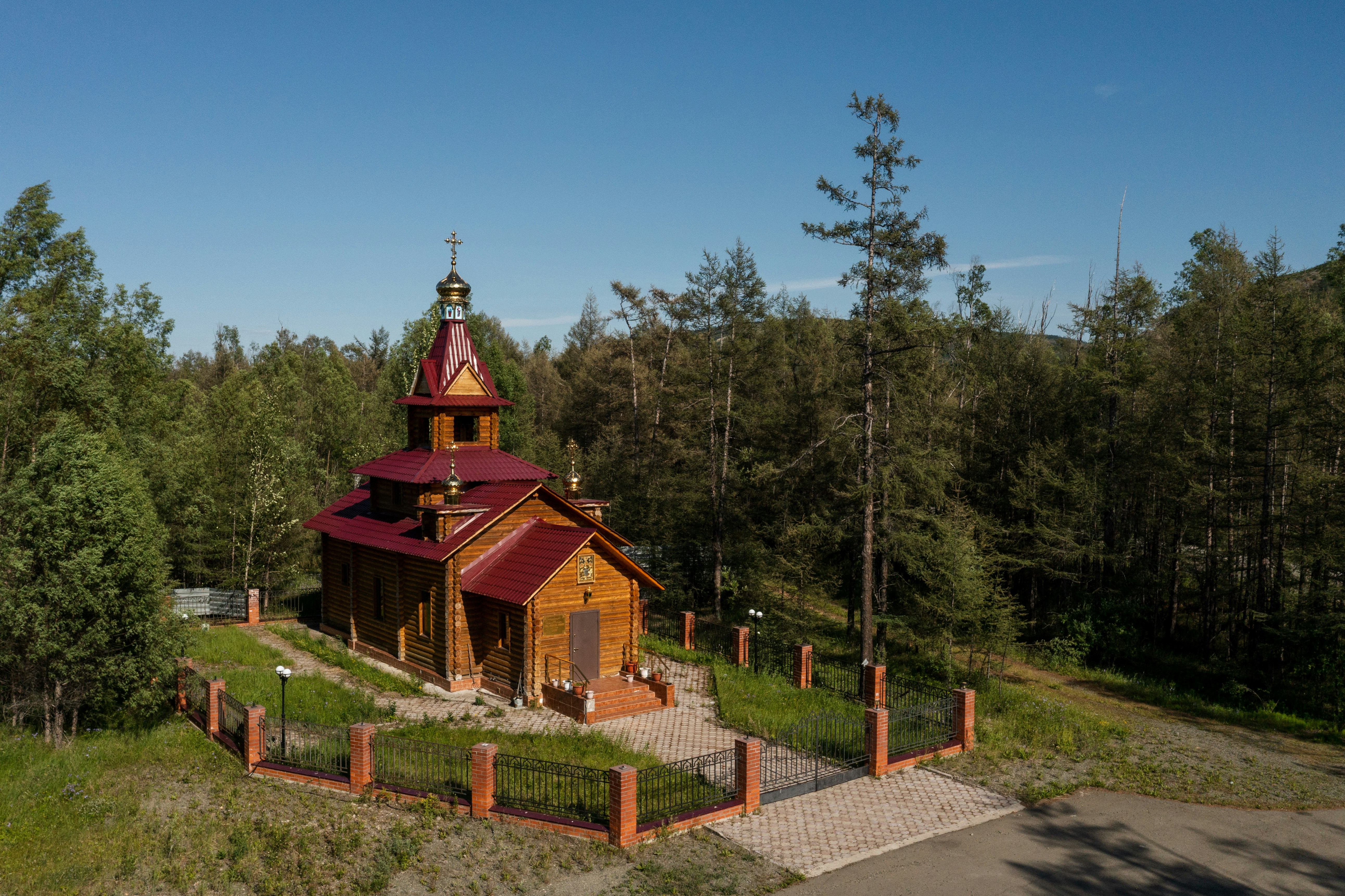 Wooden church surrounded by trees under a clear sky