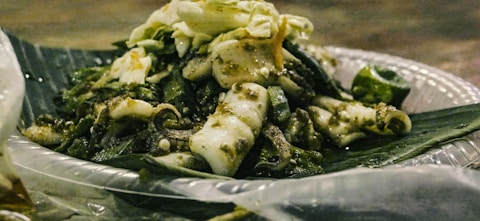 Squid and vegetables served on a banana leaf.