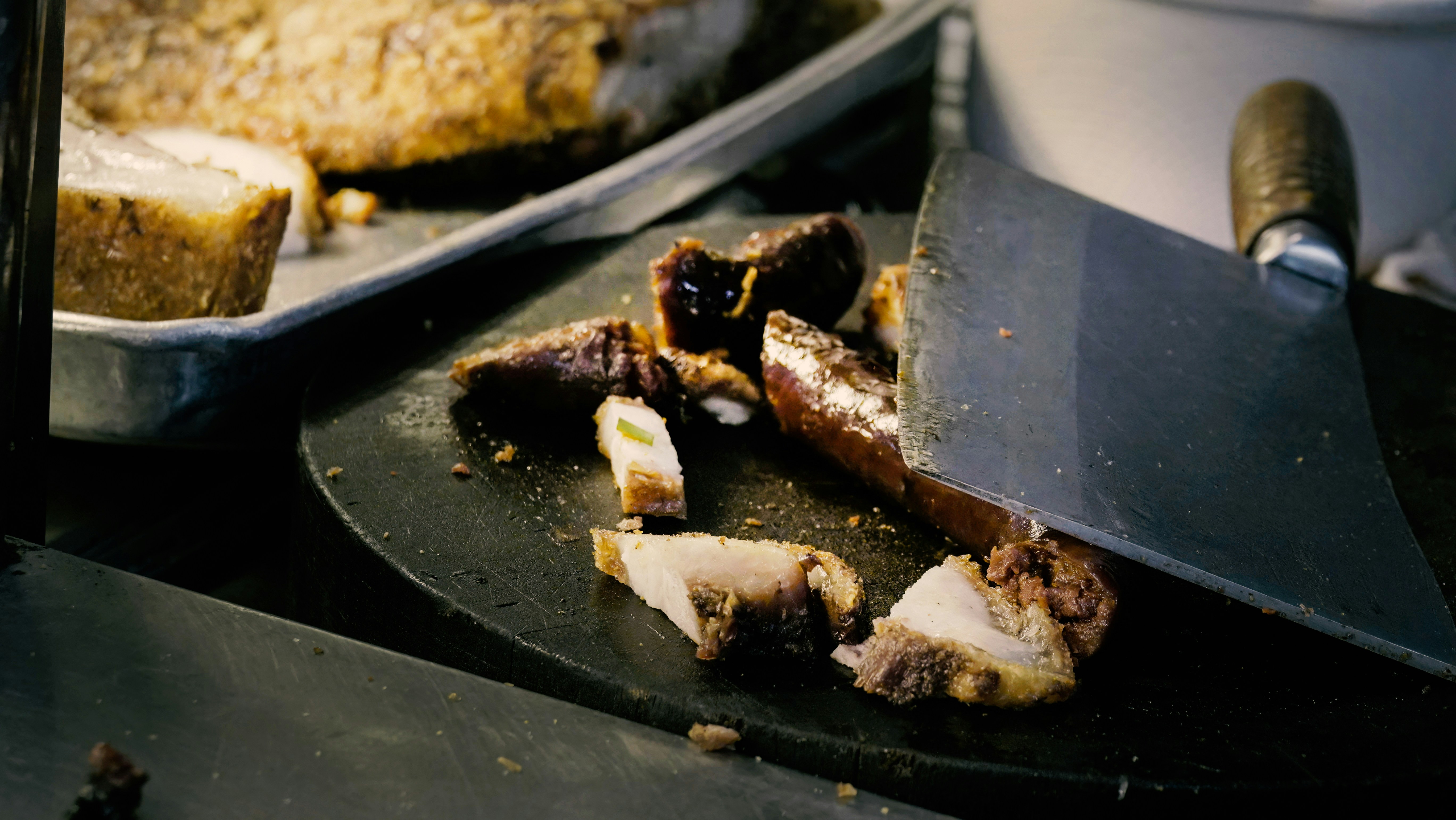 Chef chopping roasted meat with a cleaver