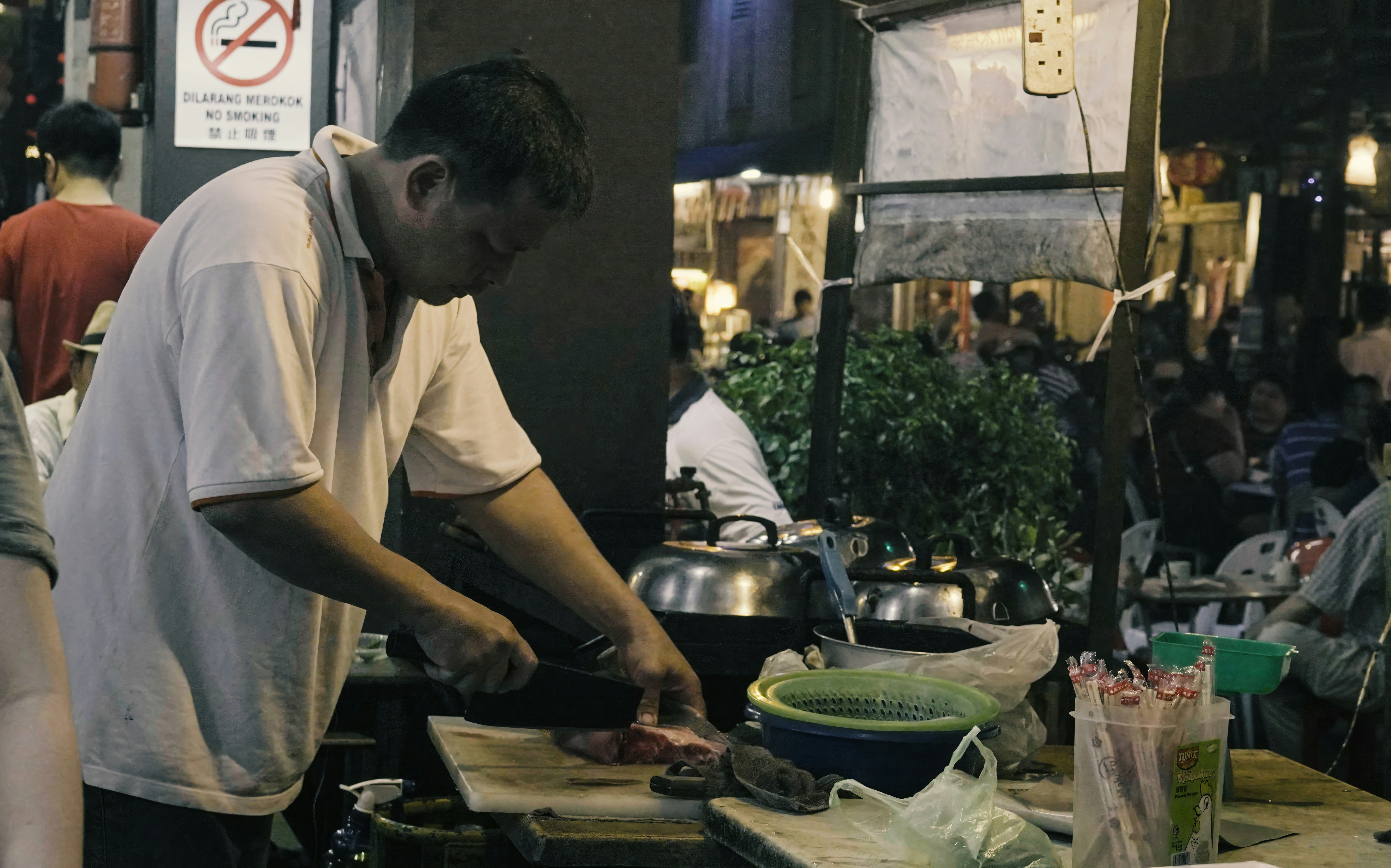 Man preparing food at a busy night market