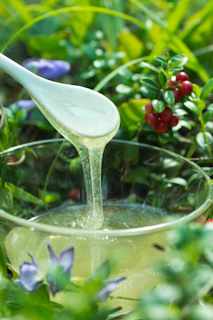 Honey dripping from spoon into a glass bowl