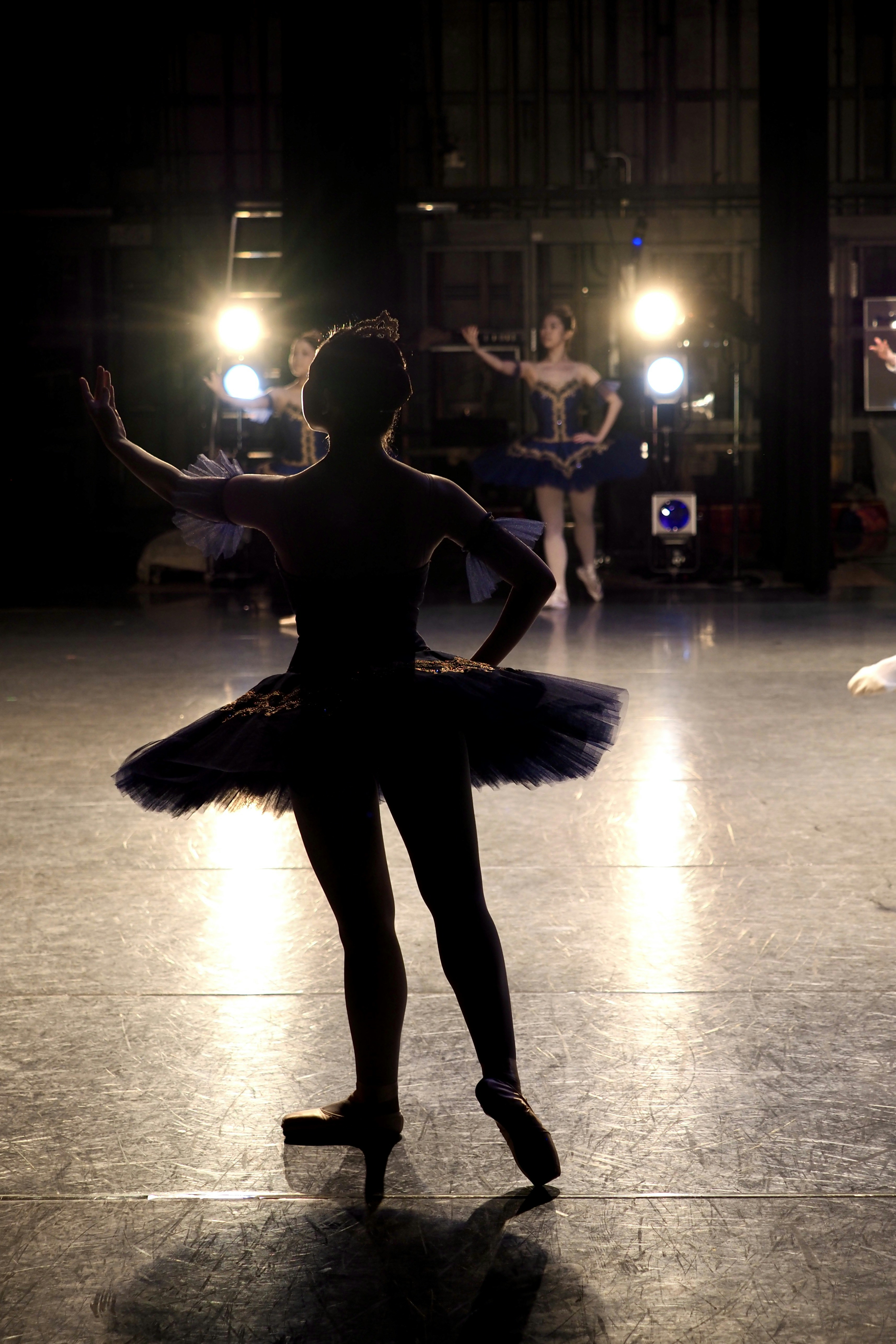 Ballerinas rehearsing on a dimly lit stage