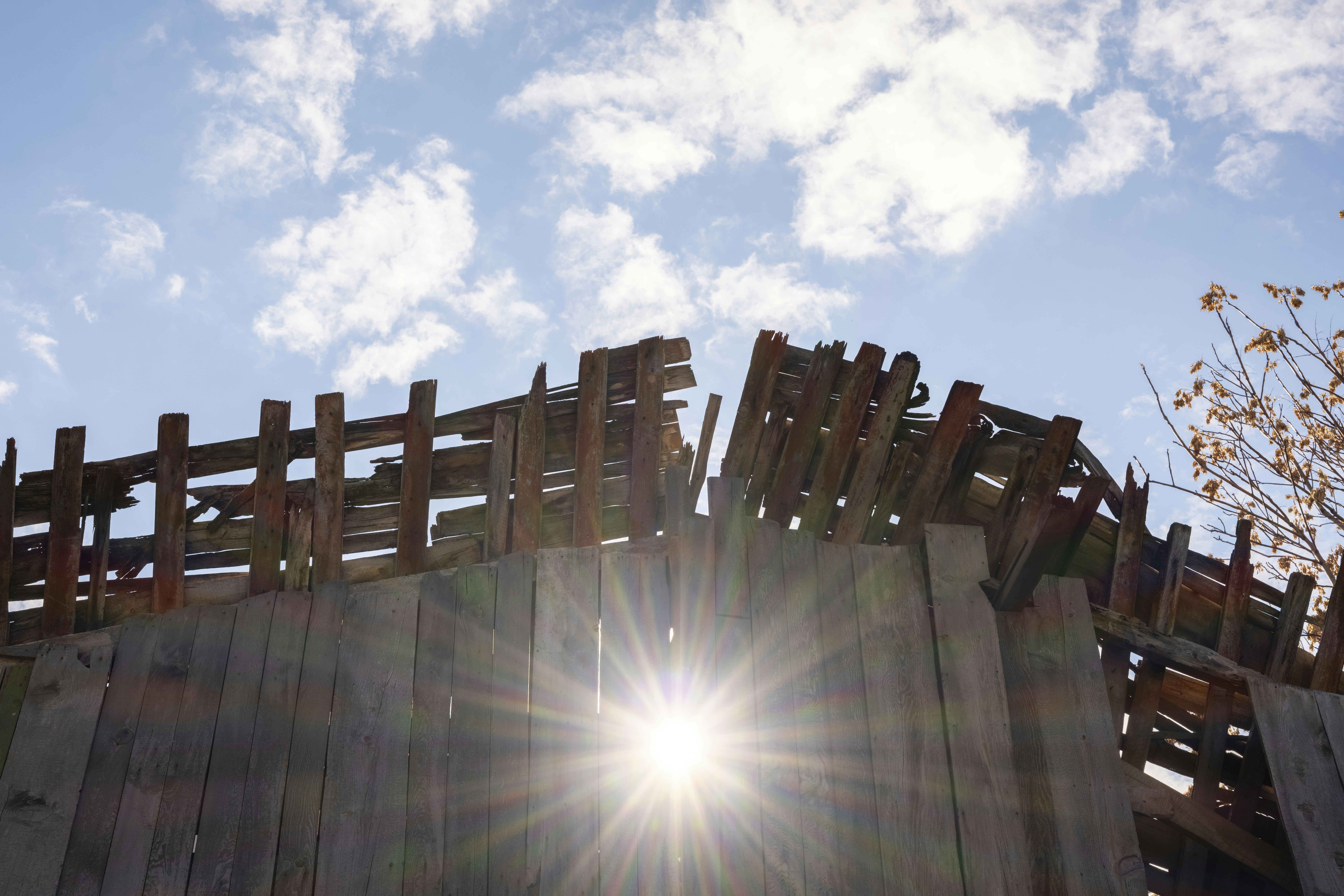 Sun shines through a dilapidated wooden structure