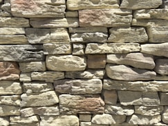 A textured wall made of stacked natural stones.