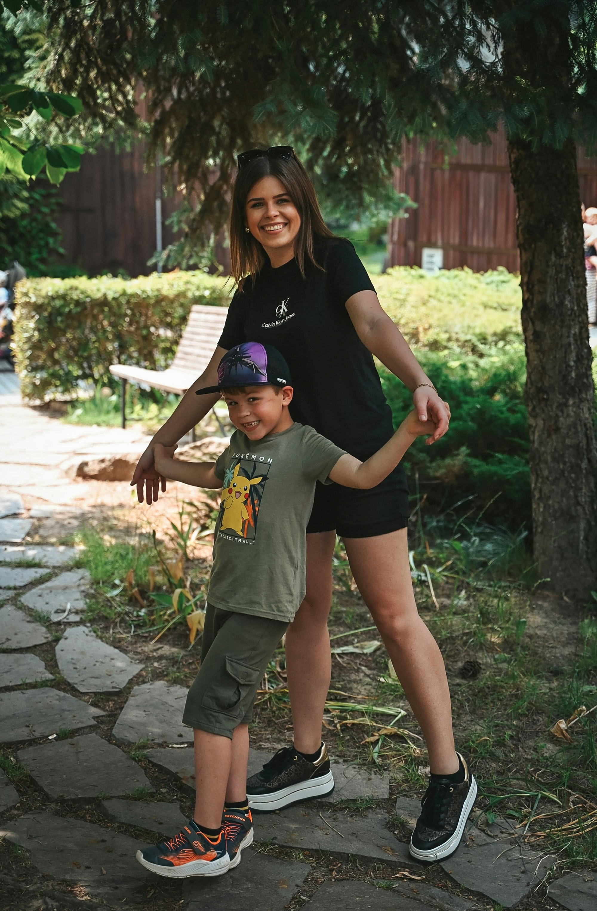 Mujer y niño posando al aire libre en el parque