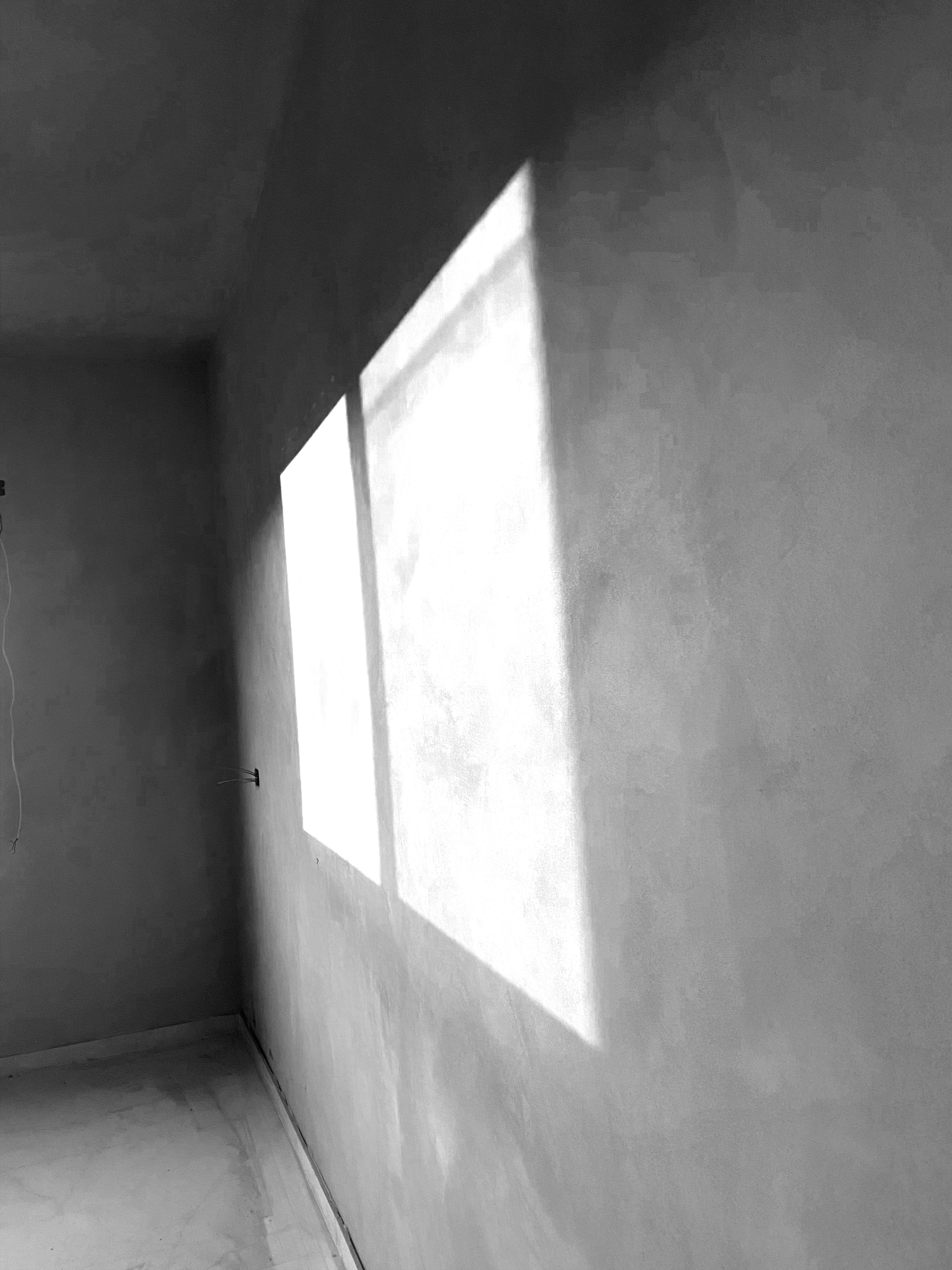 La luz del sol entra por una ventana hacia una pared.