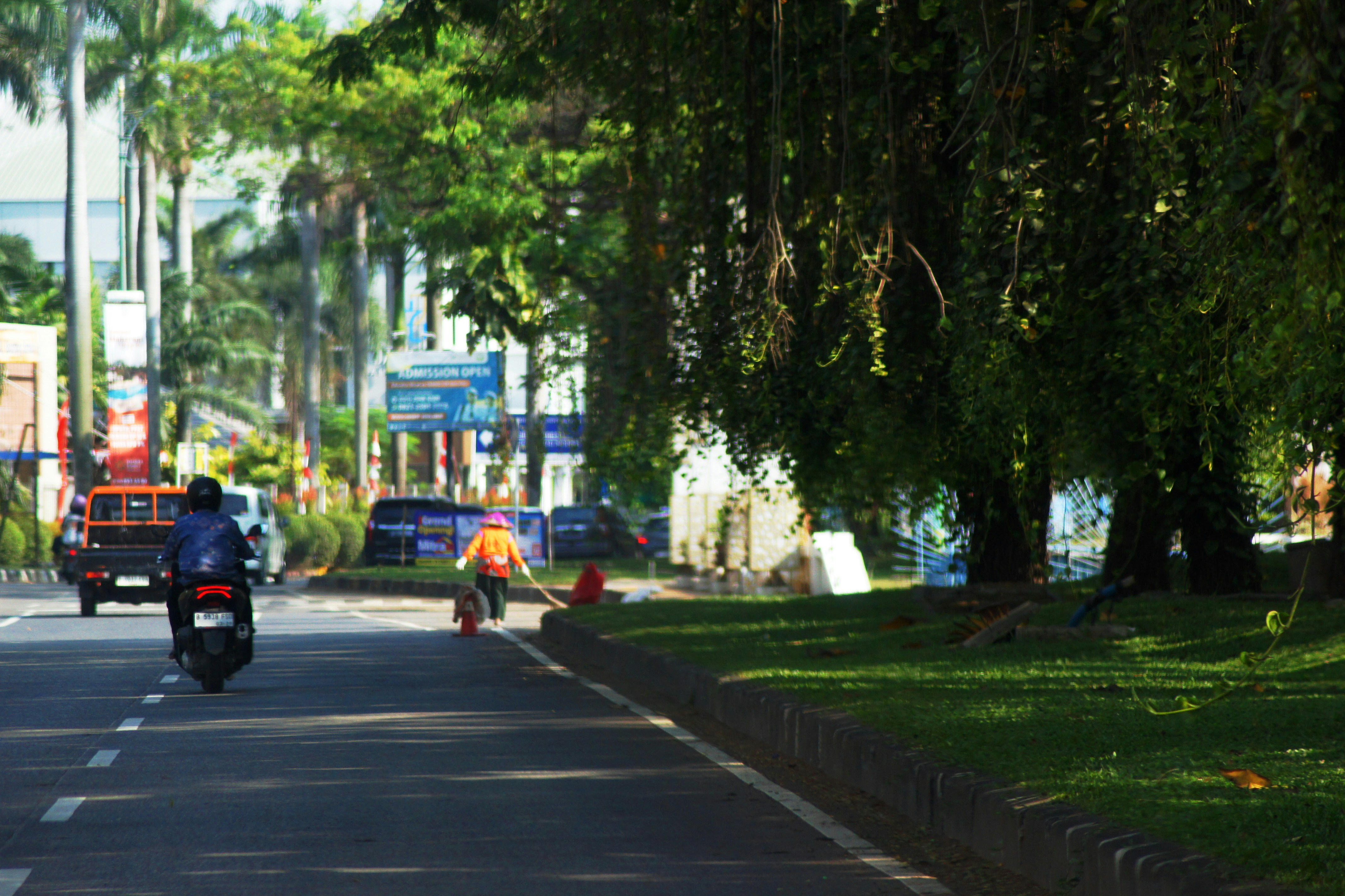 Street scene with people working and vehicles.