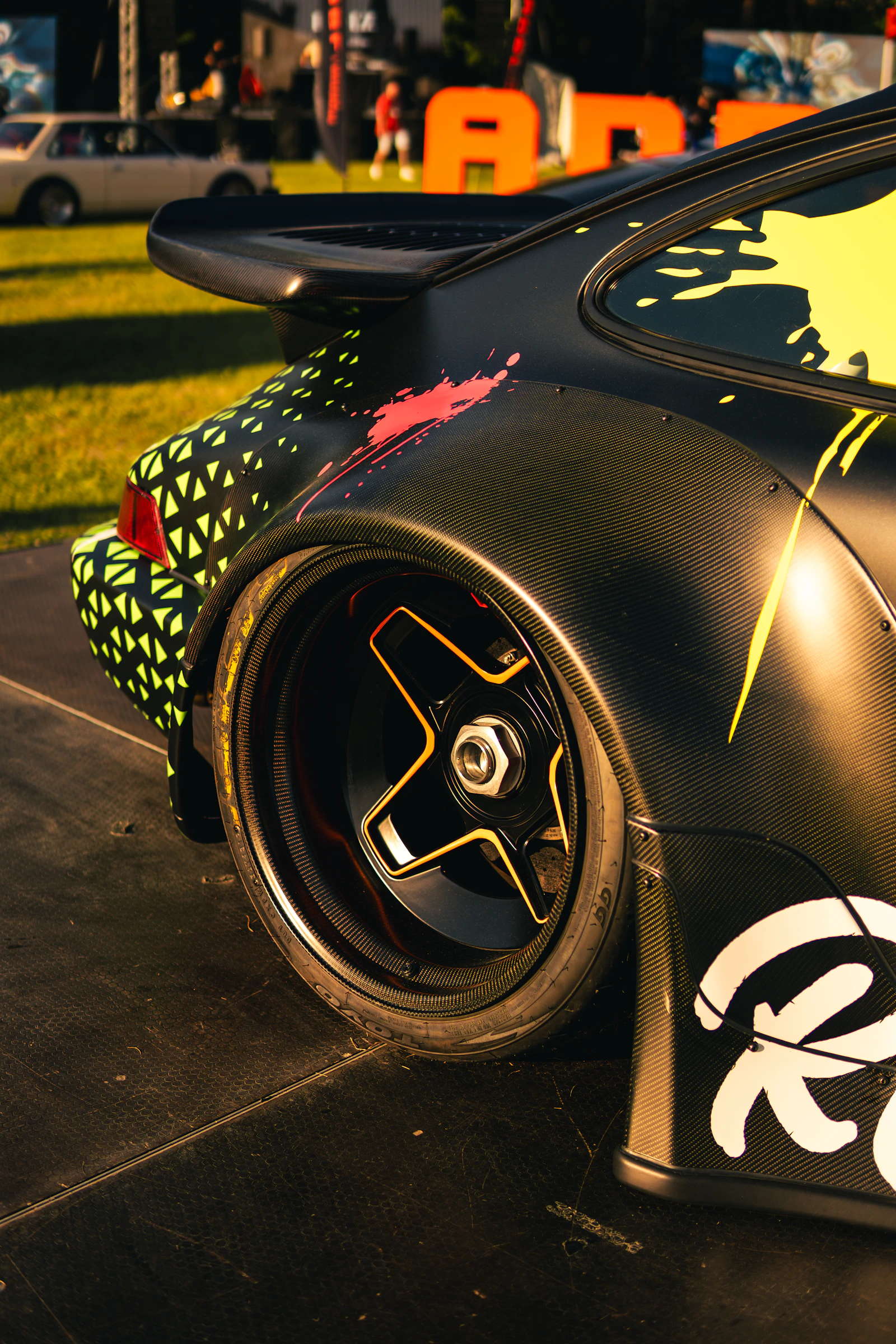 Custom sports car with vibrant paint splatter wrap