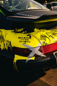 Black car with yellow abstract design and text.