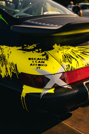 Black car with yellow abstract design and text.