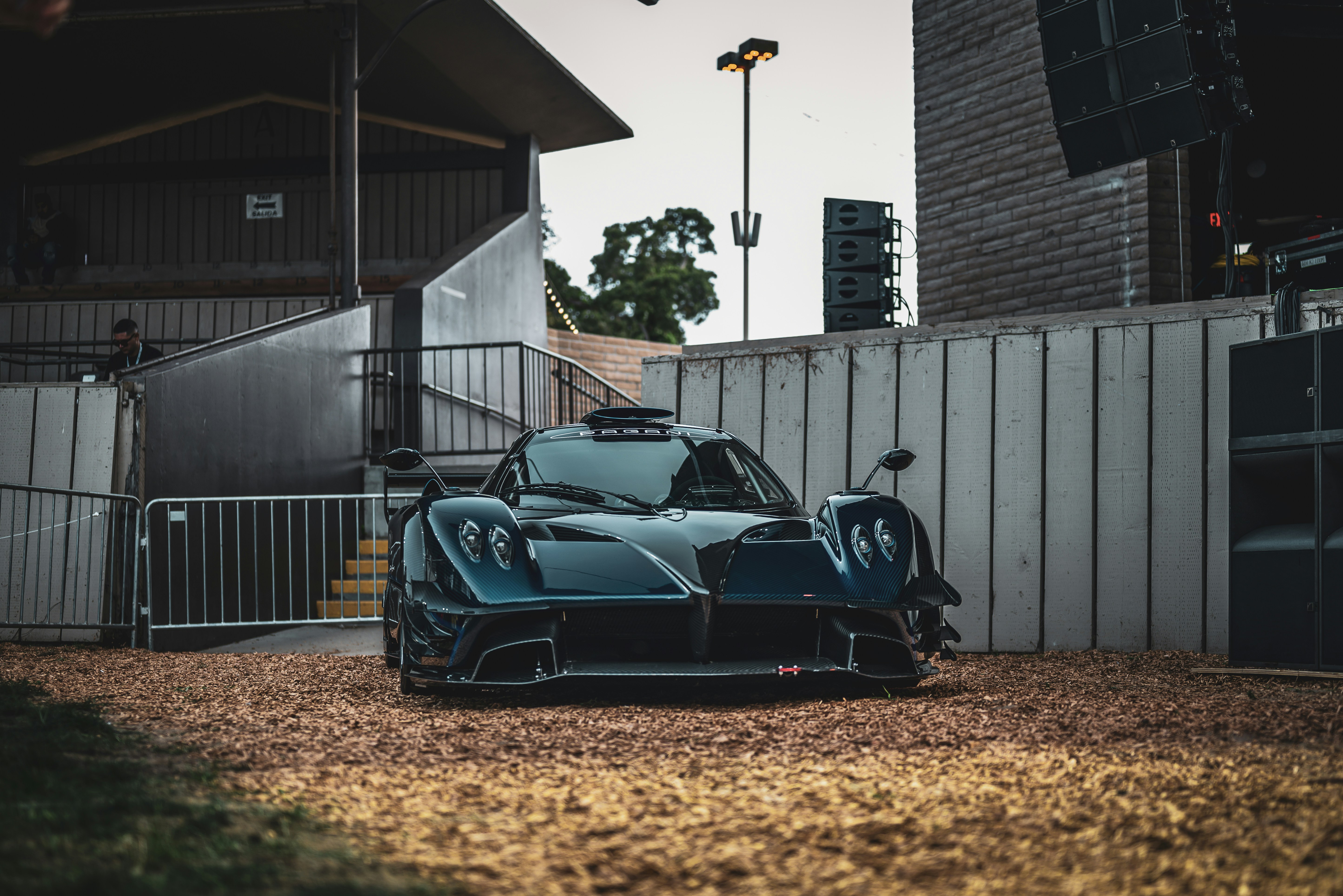 Um carro esportivo azul escuro estacionado no cascalho