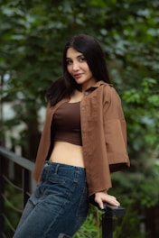 A young woman in a brown shirt and jeans outdoors