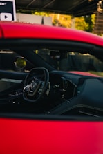 Interior of a red sports car with steering wheel.