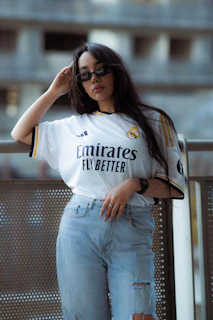 Woman in real madrid jersey and ripped jeans
