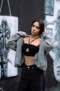 Woman in crop top and jacket against graffiti wall