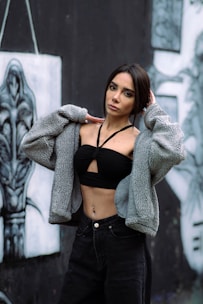 Woman in crop top and jacket against graffiti wall