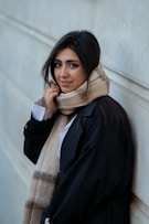 Young woman with scarf leaning against wall
